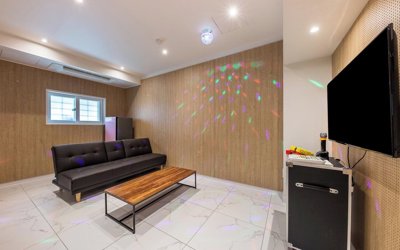 Ein modernes Wohnzimmer mit einer Couch, einem Couchtisch und einem an der Wand befestigten Flachbildfernseher.