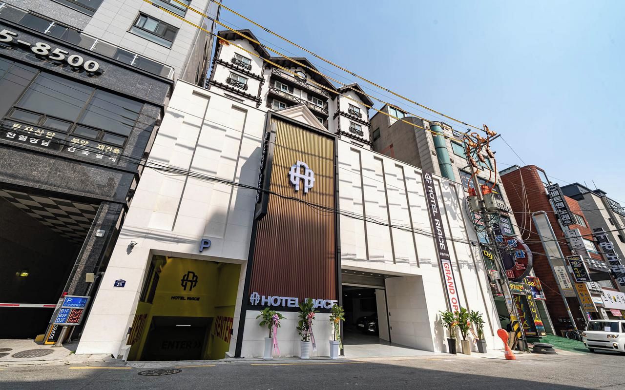 A hotel with a prominent entrance, a large sign, and a visible address.
