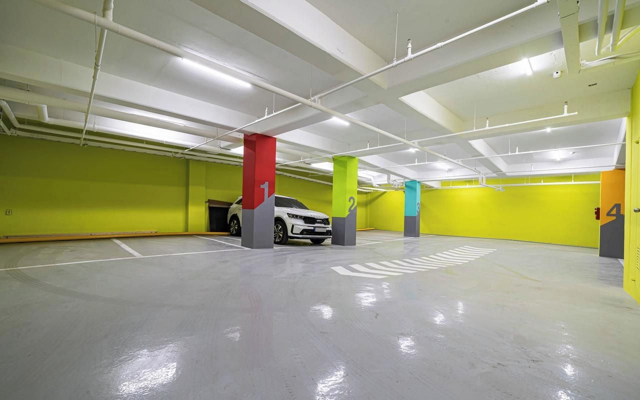 A multi-level parking garage with clearly marked parking spaces and a white car parked in one of the spaces.