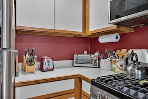 A kitchen with a gas stove, a toaster, a kettle, and a knife block. - White Loop Condo 2 Bedroom Condo (Ludlow)