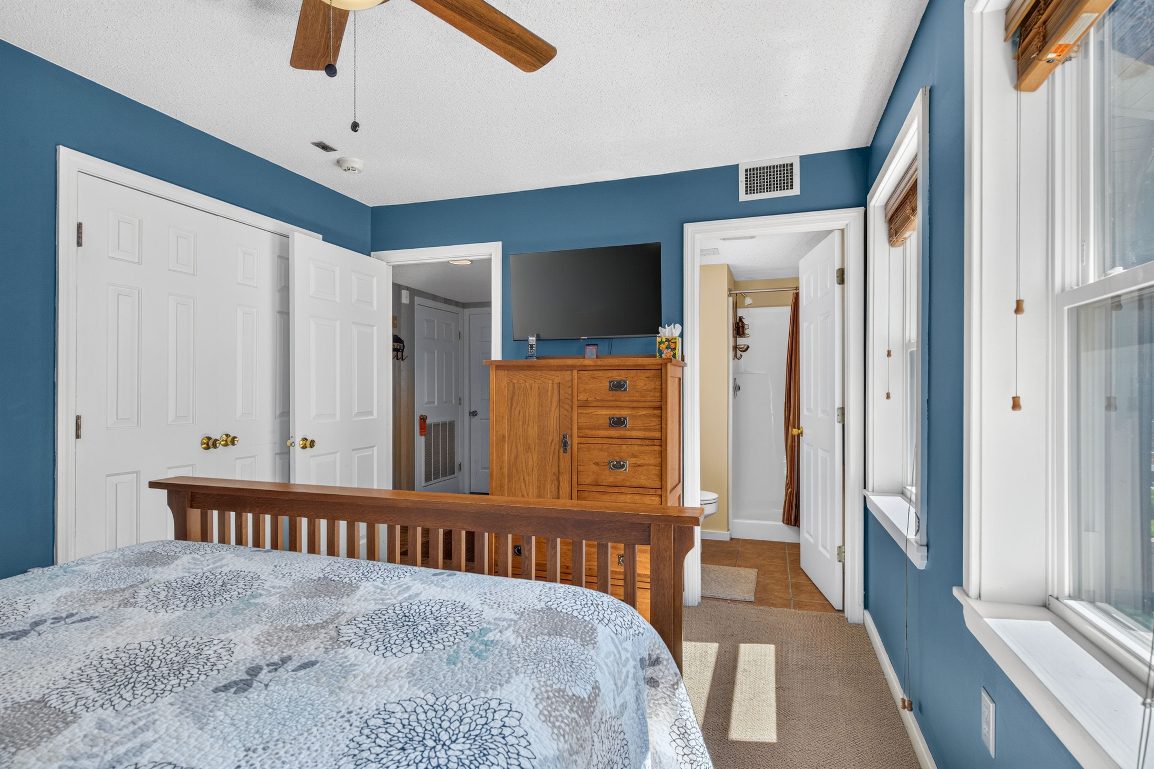 Un dormitorio con cama, cómoda y televisor.