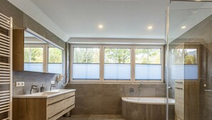 A modern bathroom with a freestanding bathtub, a double vanity, and a glass shower enclosure. - Apartment With 1 Bedroom (Sankt Georgen am Kreischberg)