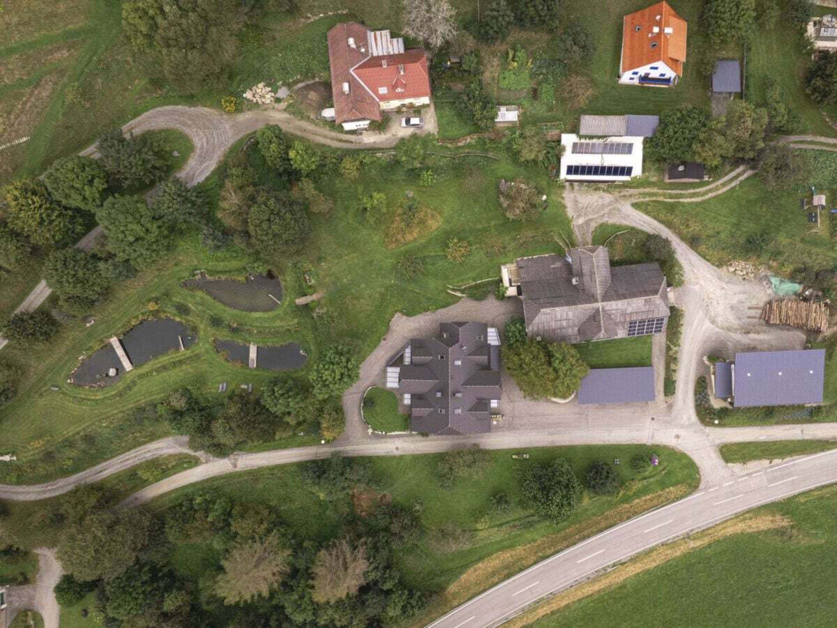 Vista aérea de una zona residencial con varias casas, calles y espacios verdes.