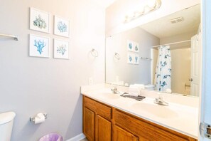 A bathroom with a white sink, wooden vanity, and a large mirror. - 301 Chester Street: 2  BR, 2  BA Condominium in Myrtle Beach, Sleeps 7 (Myrtle Beach)