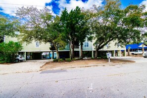 A two-story building with a covered parking area and a driveway leading to the entrance. - 301 Chester Street: 2  BR, 2  BA Condominium in Myrtle Beach, Sleeps 7 (Myrtle Beach)