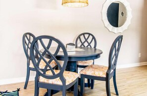 A dining area with a round table and four chairs with a crisscross back design. - 301 Chester Street: 2  BR, 2  BA Condominium in Myrtle Beach, Sleeps 7 (Myrtle Beach)