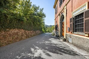 A narrow cobblestone street flanked by a stone wall and a building with a wooden door and shutters. - Room 'Palazzo Degli Angeli King Views' with Mountain & Village Views, Wi-Fi and Air Conditioning (Fivizzano)