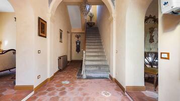 Un'imponente sala con una scalinata, decorazioni elaborate alle pareti e un lampadario.