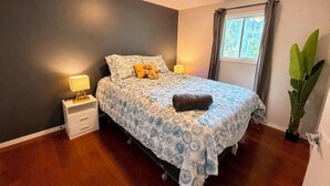 A bedroom with a bed, bedside lamps, a window with curtains, and a potted plant. - Your private terrace next to St Boniface Université and Hospital Ver Walkable (Winnipeg)