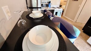 A modern kitchen with dark cabinetry, stainless steel appliances, and a dining area with a patterned bench. - Your private terrace next to St Boniface Université and Hospital Ver Walkable (Winnipeg)