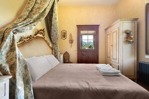 Ein Schlafzimmer mit Bett, Schrank, Stuhl und Fenster.