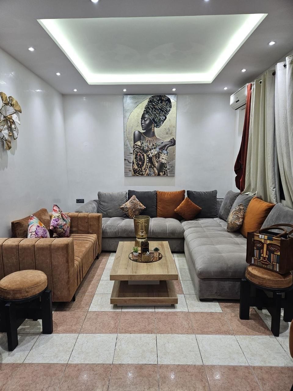Una sala moderna con un sofá seccional, una mesa de centro y una obra de arte colgada en la pared.