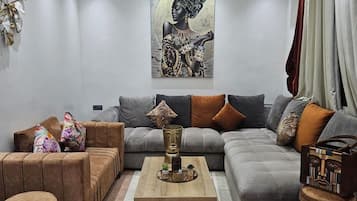 Una sala moderna con un sofá seccional, una mesa de centro y una obra de arte colgada en la pared.