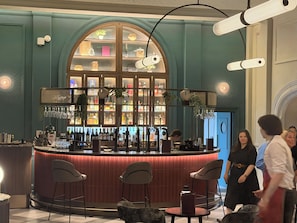 A bar area with a curved counter, bar stools, and a variety of bottles and glasses. - Yellow B&B (York)