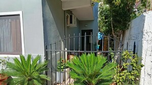 Una entrada protegida con plantas en macetas y la entrada de un edificio.