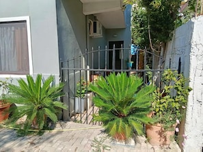 A gated entrance with potted plants and a building entrance. - Rezidenca Pahumi  (Durrës)