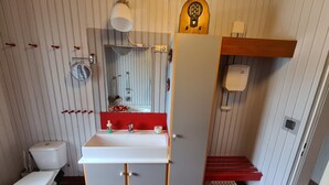 Un baño con inodoro, lavamanos, espejo y ducha.