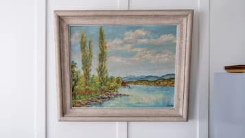 A framed landscape painting on a white wall.