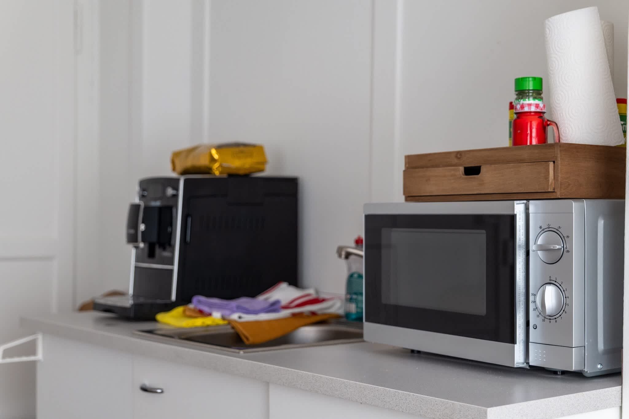 A kitchen with a microwave, a coffee maker, and a small box on the counter.