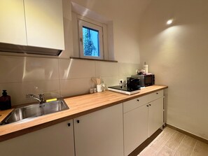 A kitchen with a stainless steel sink, wooden countertop, and white cabinets. - Your elegant retreat in Pisa, in the heart of Tuscany (Pisa)