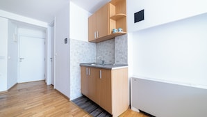Una cocina moderna con gabinetes de madera, un lavamanos empotrado y un salpicadero de azulejos.