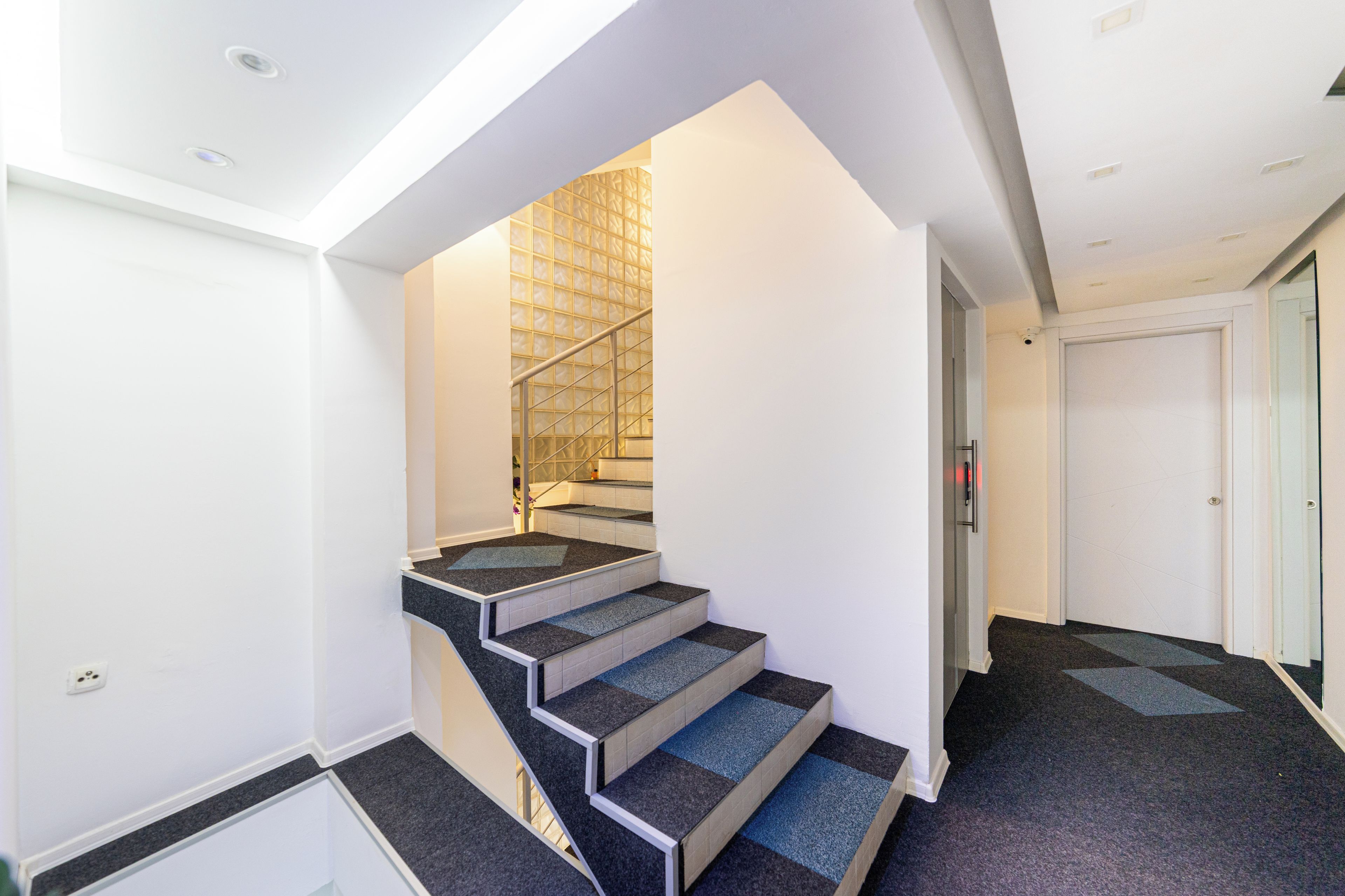 Un escalier agrémenté d’un mur aux motifs géométriques et doté d’un design moderne.