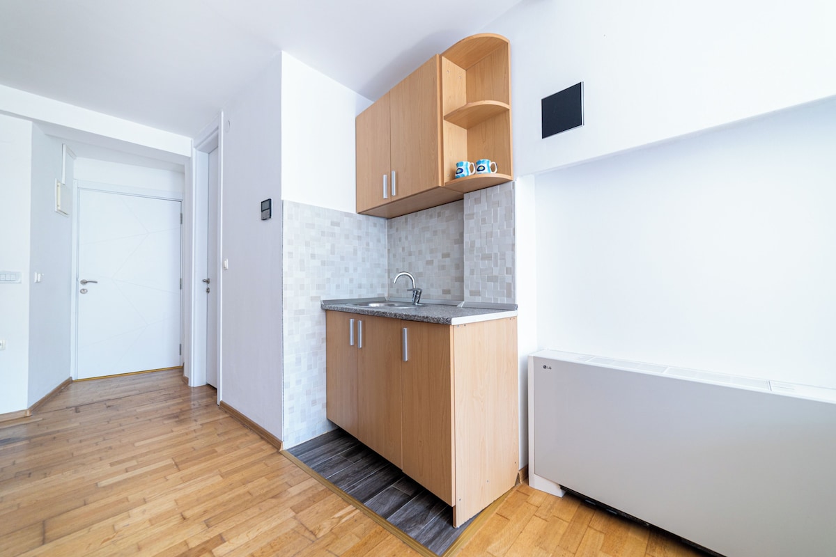 A modern kitchen with wooden cabinets, a built-in sink, and a tiled backsplash.