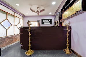 A hotel reception desk with a sign indicating it is company-serviced. - Deluxe kk Residency (Karaikal)