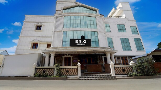 A hotel with a prominent 'HOTEL' sign, a classic architectural style, and a gated entrance. - Deluxe kk Residency (Karaikal)
