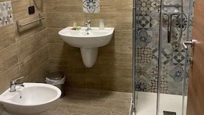 Ein Badezimmer mit Dusche, Bidet und Waschbecken.