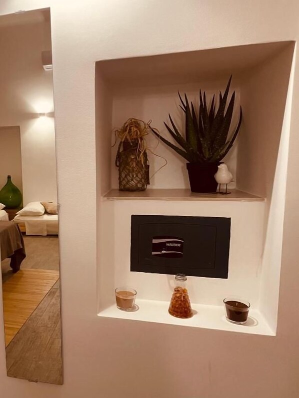 A wall-mounted shelf with a potted plant, a decorative item, a small vase, and a framed item.