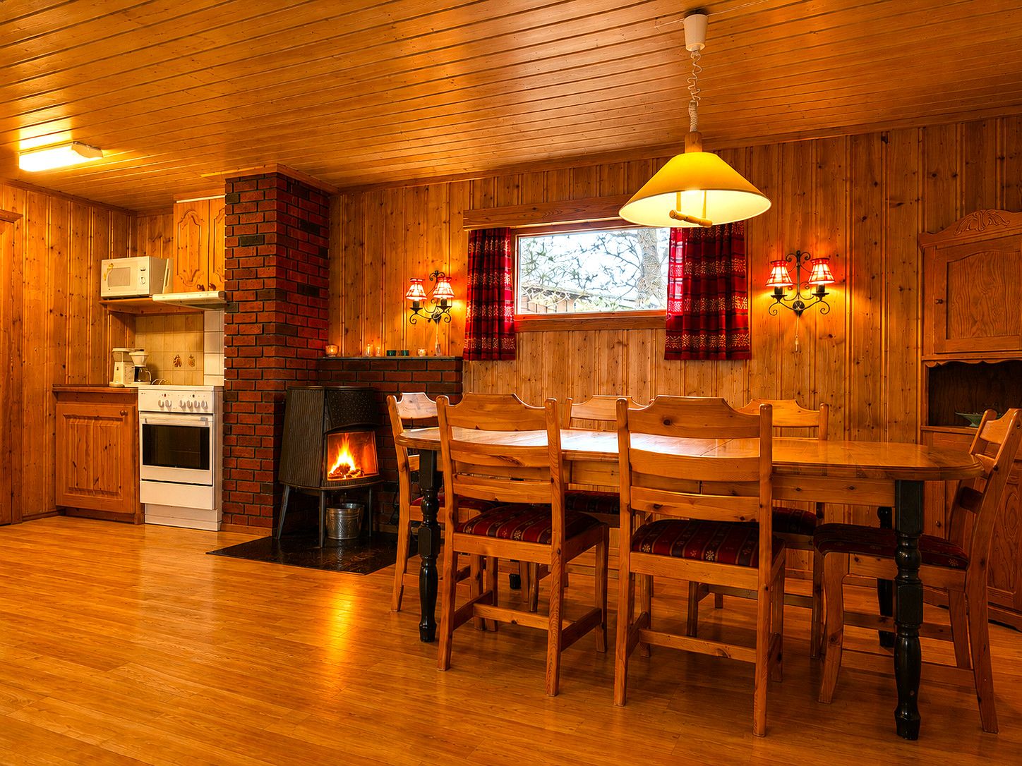 Un accogliente interno in legno con camino, tavolo da pranzo e sedie.