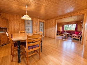 Ein Holzinterieur mit Esstisch, Stühlen und einer Sitzecke.