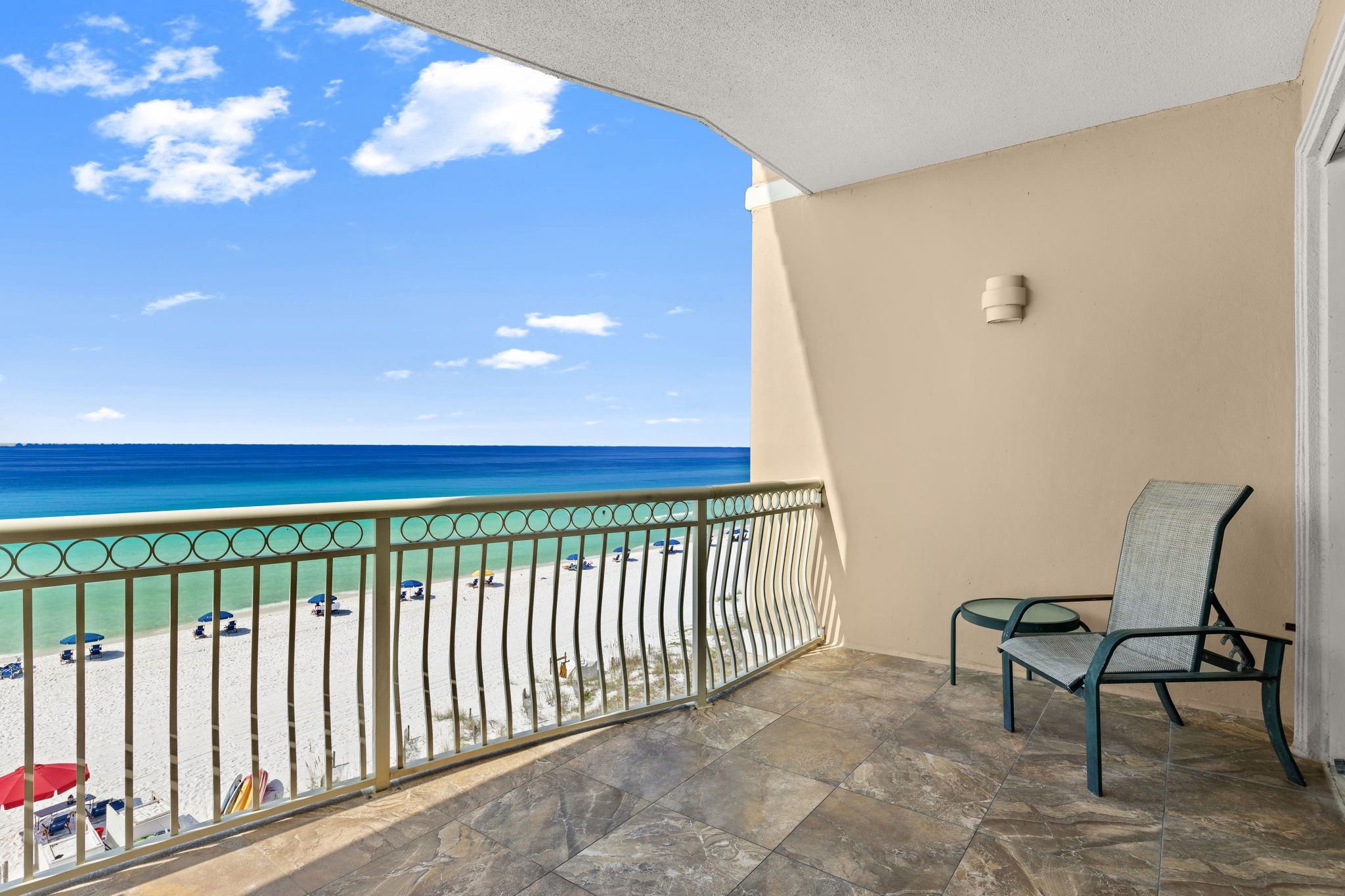 Un balcon avec vue sur une plage et l’océan.