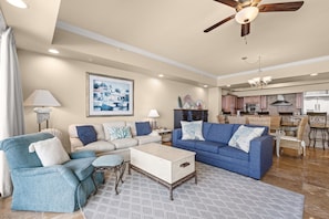 A spacious living room with a sofa set, a coffee table, and a ceiling fan. - Spacious Coastal Retreat | Complimentary Beach Service (Destin)