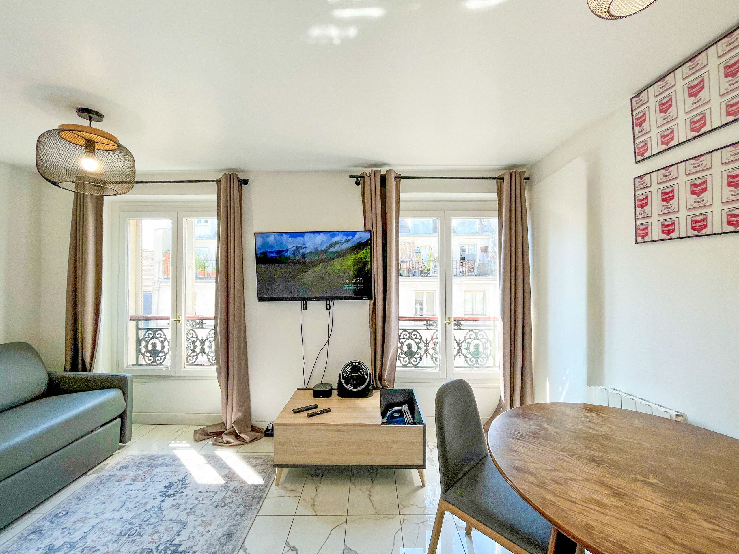 Un salon moderne avec un téléviseur à écran plat, un canapé, une table à manger et une table basse.