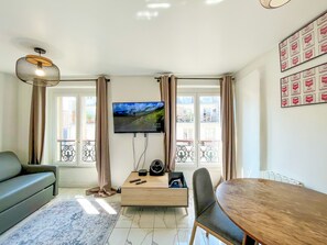 A modern living room with a flat-screen TV, a sofa, a dining table, and a coffee table. - 143 - Urban Charming Flat in Center of Paris (París)