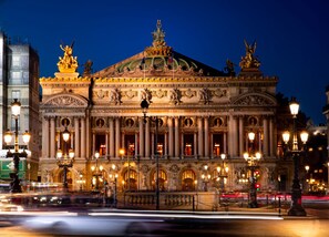 Ein imposantes Gebäude mit klassischer Architektur, das Säulen, Statuen und aufwendige Verzierungen aufweist.
