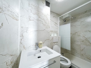 A bathroom with a white sink, toilet, and shower. - 163 - Urban Studio in Paris (París)