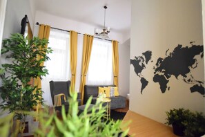 A living room with a sofa, a small table, and a world map on the wall. - Hi5 Apartments - Chainbridge (Budapest)