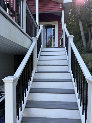 A staircase with white railings and dark steps leading to a door. - Waterfront house on Lake Wallenpaupack w/ private dock, sleeps 9, dogs allowed! (Tafton)