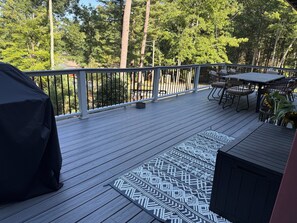 A wooden deck with outdoor furniture, including a table and chairs, and a grill. - Waterfront house on Lake Wallenpaupack w/ private dock, sleeps 9, dogs allowed! (Tafton)