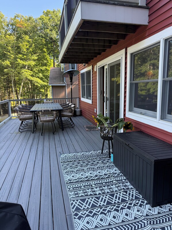 Une terrasse avec une table et des chaises, un tapis à motifs et une plante en pot.