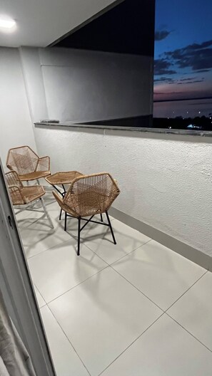 A balcony with a white tiled floor, a white textured wall, and a view of the sky at dusk. - FLAT NA MELHOR LOCALIZAÇÃO DA ORLA (Palmas)