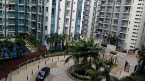 A high-rise residential building with multiple balconies, a central courtyard with palm trees, and a gated entrance. - Kim's hub at Two Palmtree Villas (Pasay City)