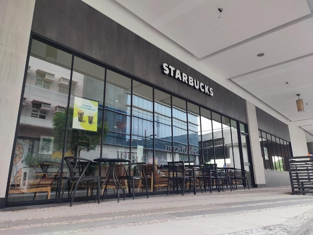 A Starbucks store with large glass windows and outdoor seating.