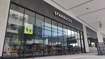 A Starbucks store with large glass windows and outdoor seating.