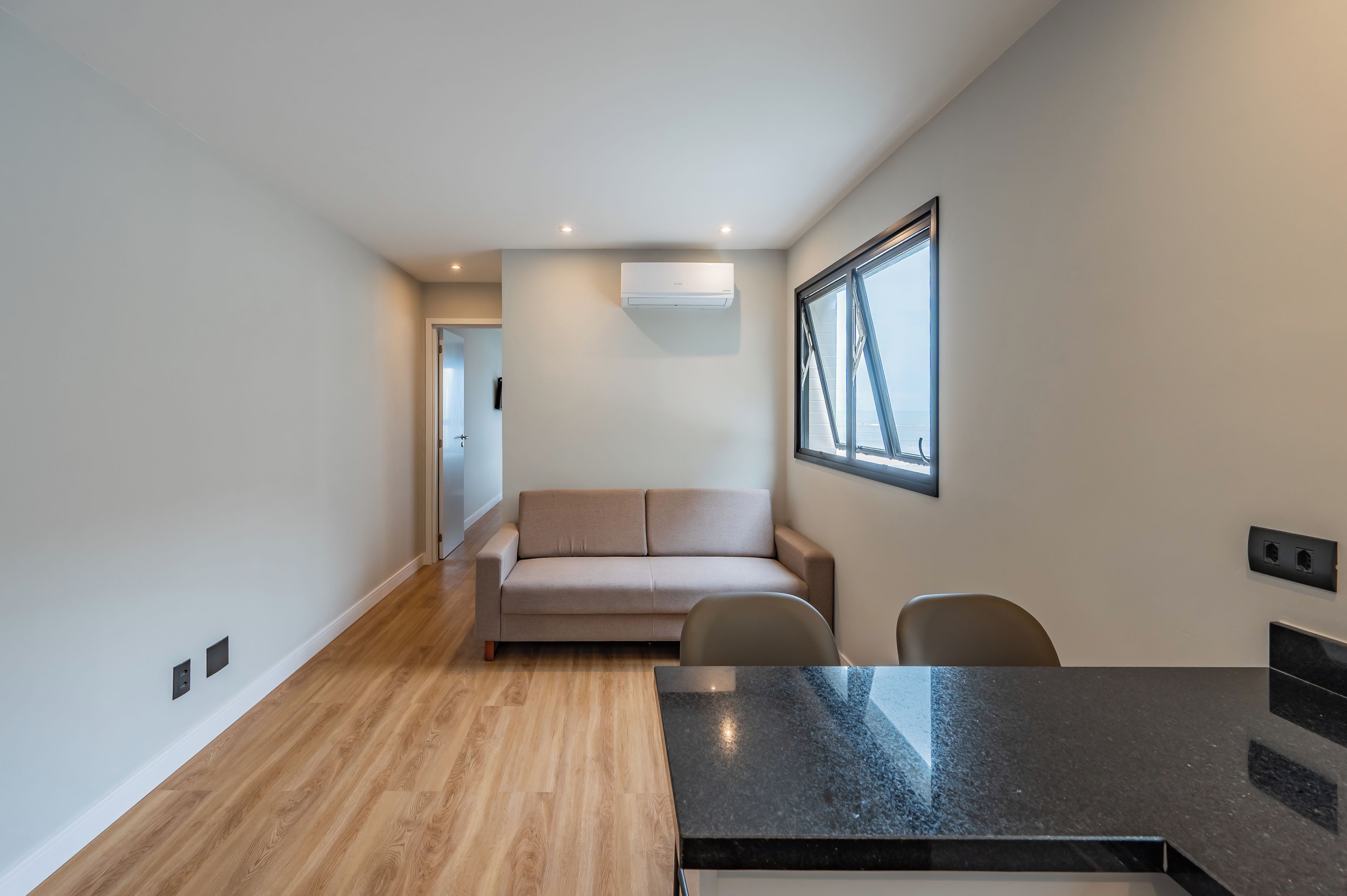Een modern interieur met een bank, stoelen, een eettafel en een raam met uitzicht.
