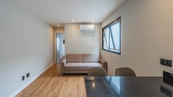 Een modern interieur met een bank, stoelen, een eettafel en een raam met uitzicht.