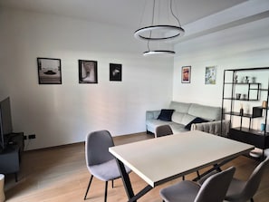 A modern living room with a sofa, a dining table, and a bookshelf. - Domus Harmoniae (Albano Laziale)